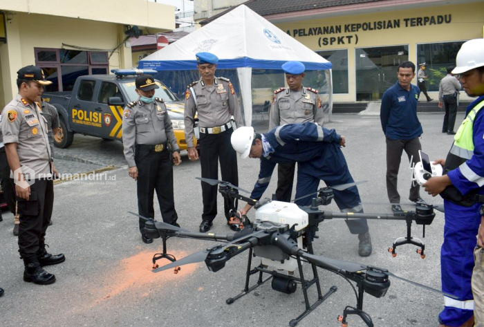 Canggih! Polisi di Riau Semprot Disinfektan ke Rumah-Rumah Warga Pakai Drone