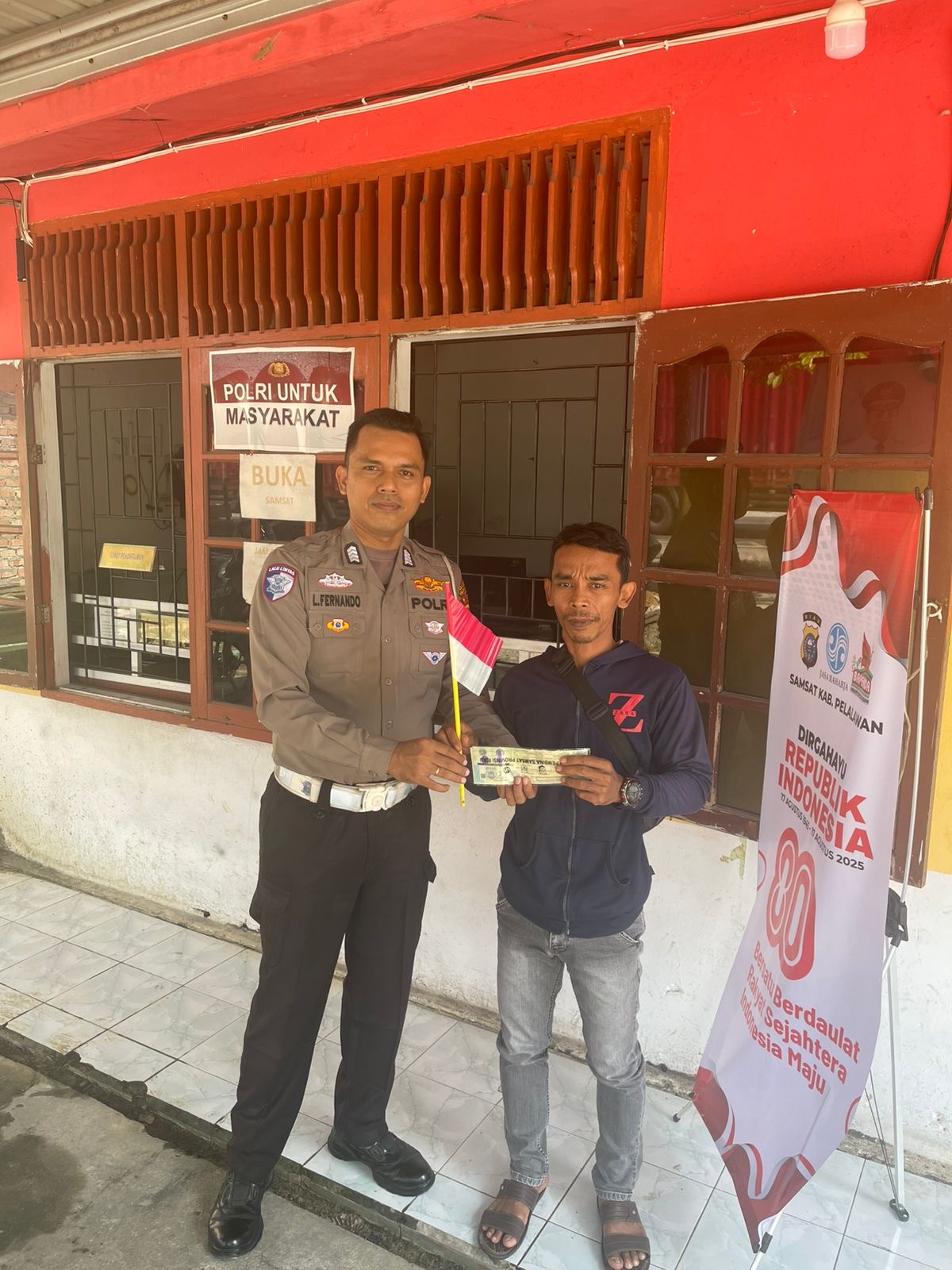 Satlantas Polres Pelalawan Berbagi Bendera di Samsat Simpang Beringin