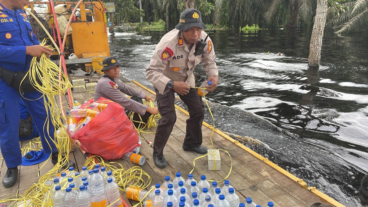 Satpolairud Polres Pelalawan Buat Rambu Botol Bekas, Penanda di Jalan Lintas Timur Terendam Banjir