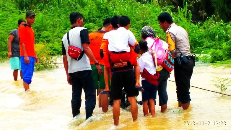 Jalan Terendam Banjir, Polisi dan Petugas KPBD Inhu Gendong Siswa Lewati Arus Deras