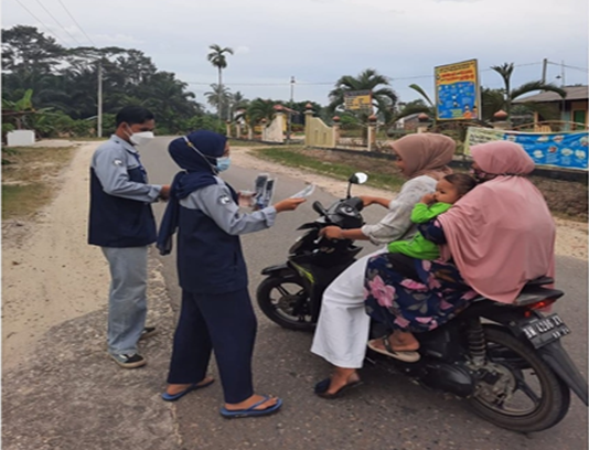 Ikuti Tren, Mahasiswa Kukerta Unri Bagi-Bagi Konektor dan Strap Masker di Desa Geringging Jaya